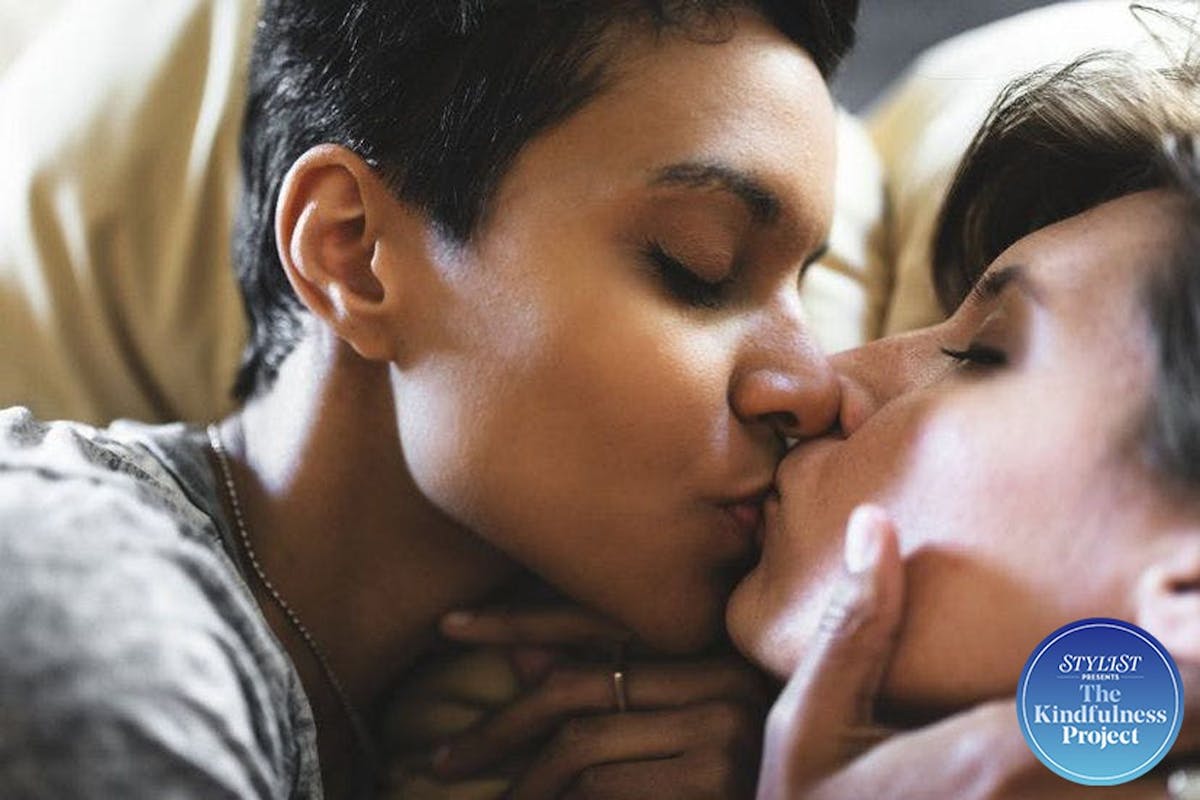 Two women kissing in bed